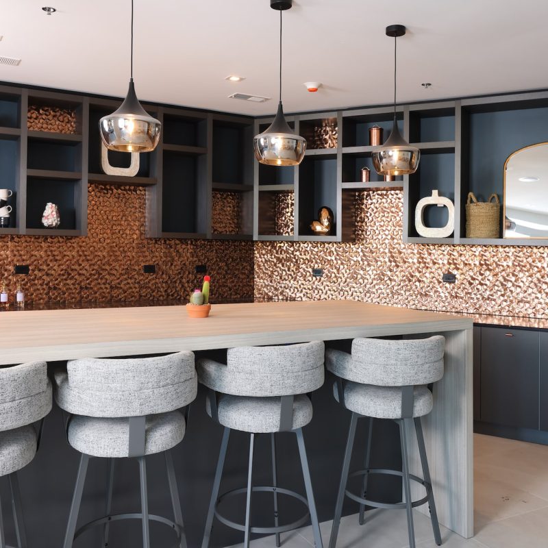 Station 250 community kitchen and bar area with modern cabinetry, bar seating, and entertainment space Mundelein IL