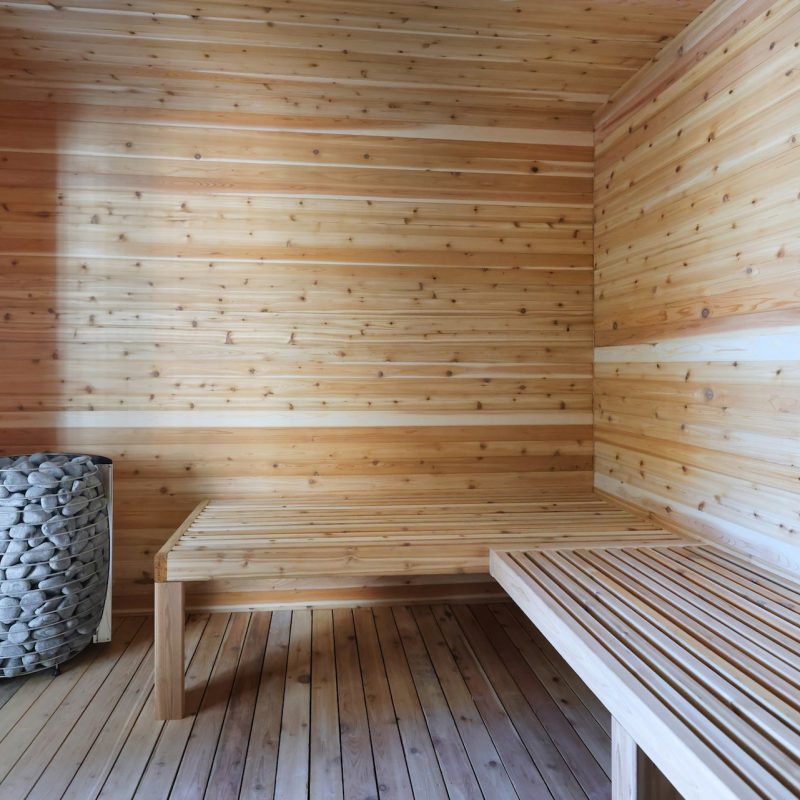 Indoor sauna with natural cedar wood paneling and bench seating at Station 250 luxury apartment amenities Mundelein